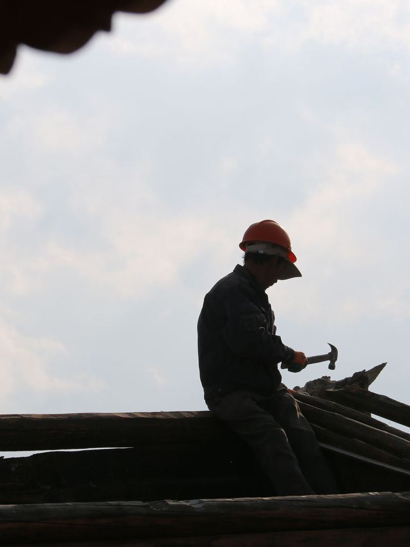 工匠在屋顶上干活 / A craftsman at work on the roof